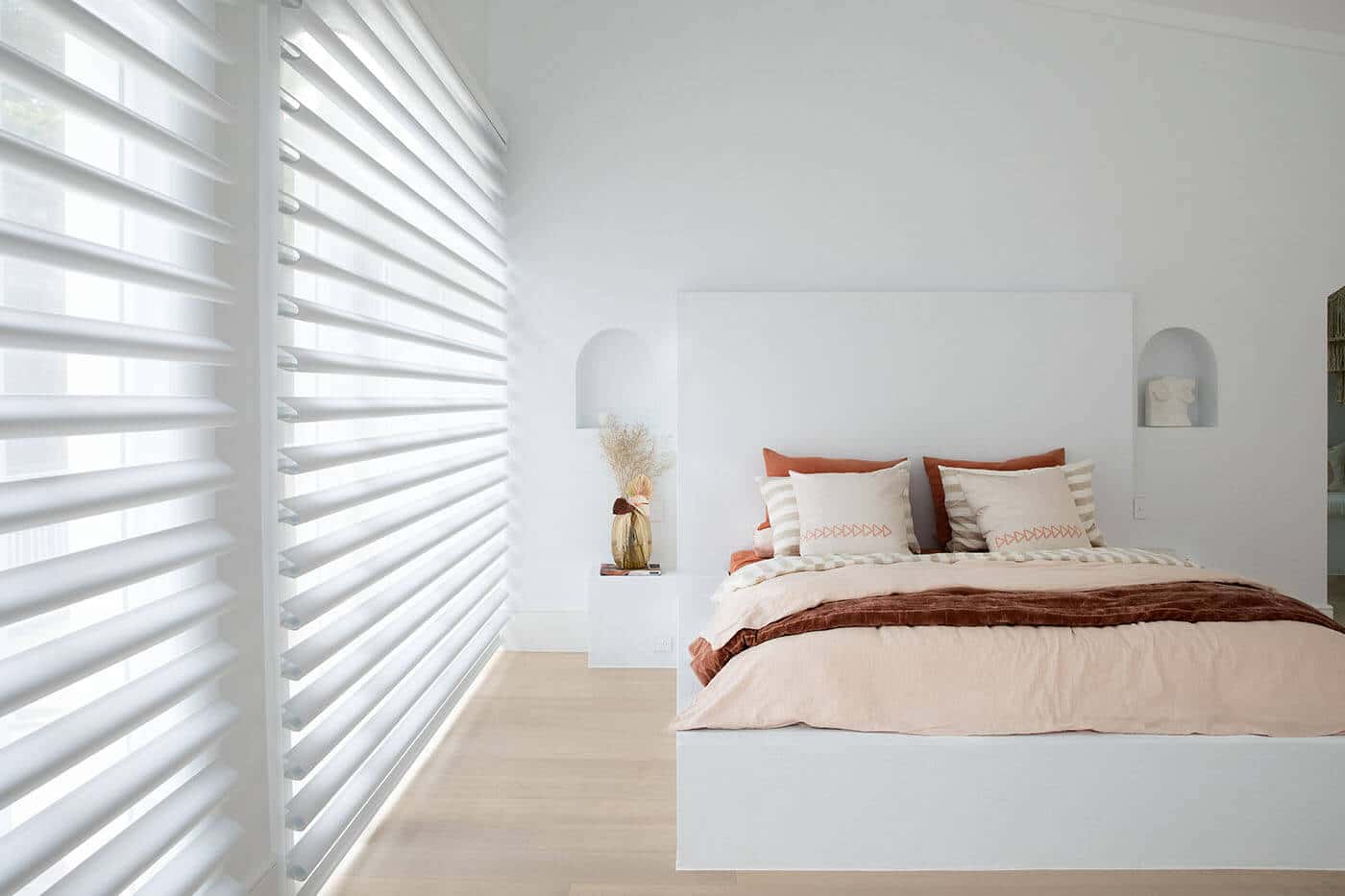 Pirouette Shades with softly curved fabric vanes allowing flexible light control and UV protection diffusing light in a cozy bedroom. Innovative and minimalist design. For sale at Complete Blinds Australia.