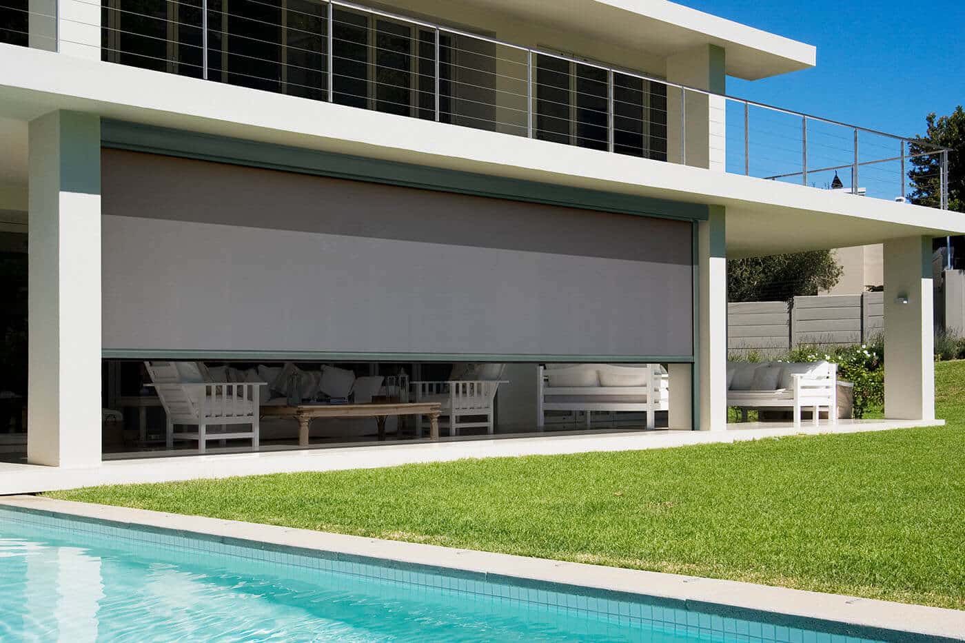 Modern contemporary home with patio, garden, and swimming pool, featuring Evo Magnatrack awnings blocking out sunlight and providing shades to the patio. For sale in our Brisbane showroom.