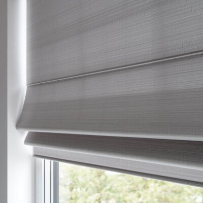 Modern minimalist room featuring grey Roman Blinds for privacy and temperature control by Complete Blinds Brisbane