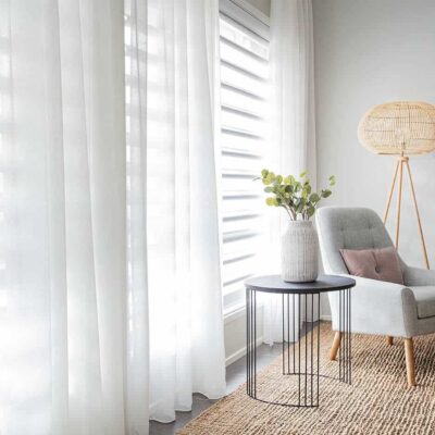 Aesthetic zen living room with ceiling-height windows installed with sheer white curtains gently filtering sunlight in to the room. Curtains for sale at Complete Blinds Redcliffe.