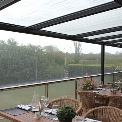 Clear PVC café blinds protecting an outdoor dining space from rain while preserving views